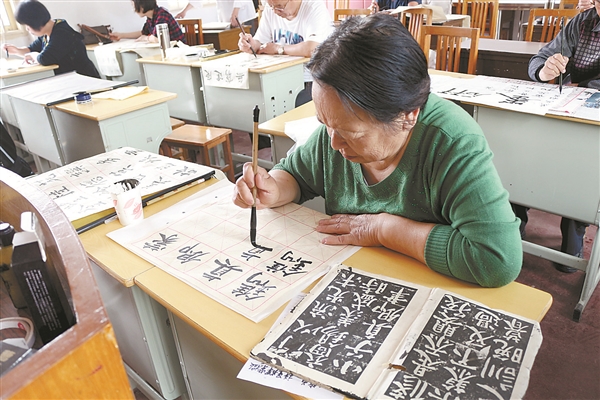 金港镇老年大学书法班学员正在认真临摹。.jpg