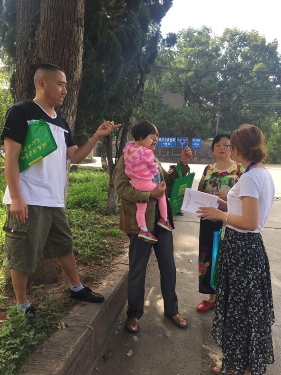 文安场社区教育工作站向居民介绍惠民政策.jpg