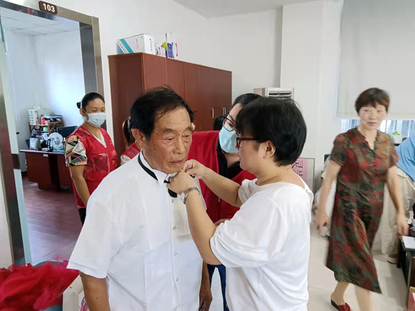 正在帮居民整理领结的灵岩社区分院校长贺丹.jpg